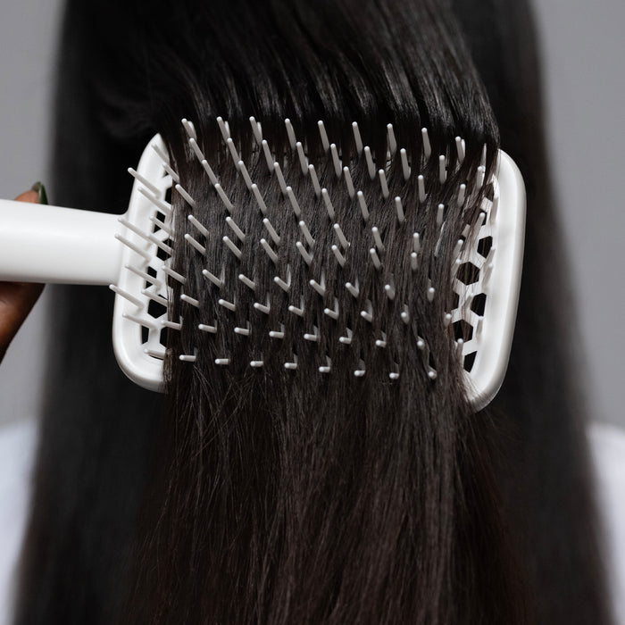 Cécred Detangling Brush in use on straight hair, showing how the flexible bristles glide without snagging.